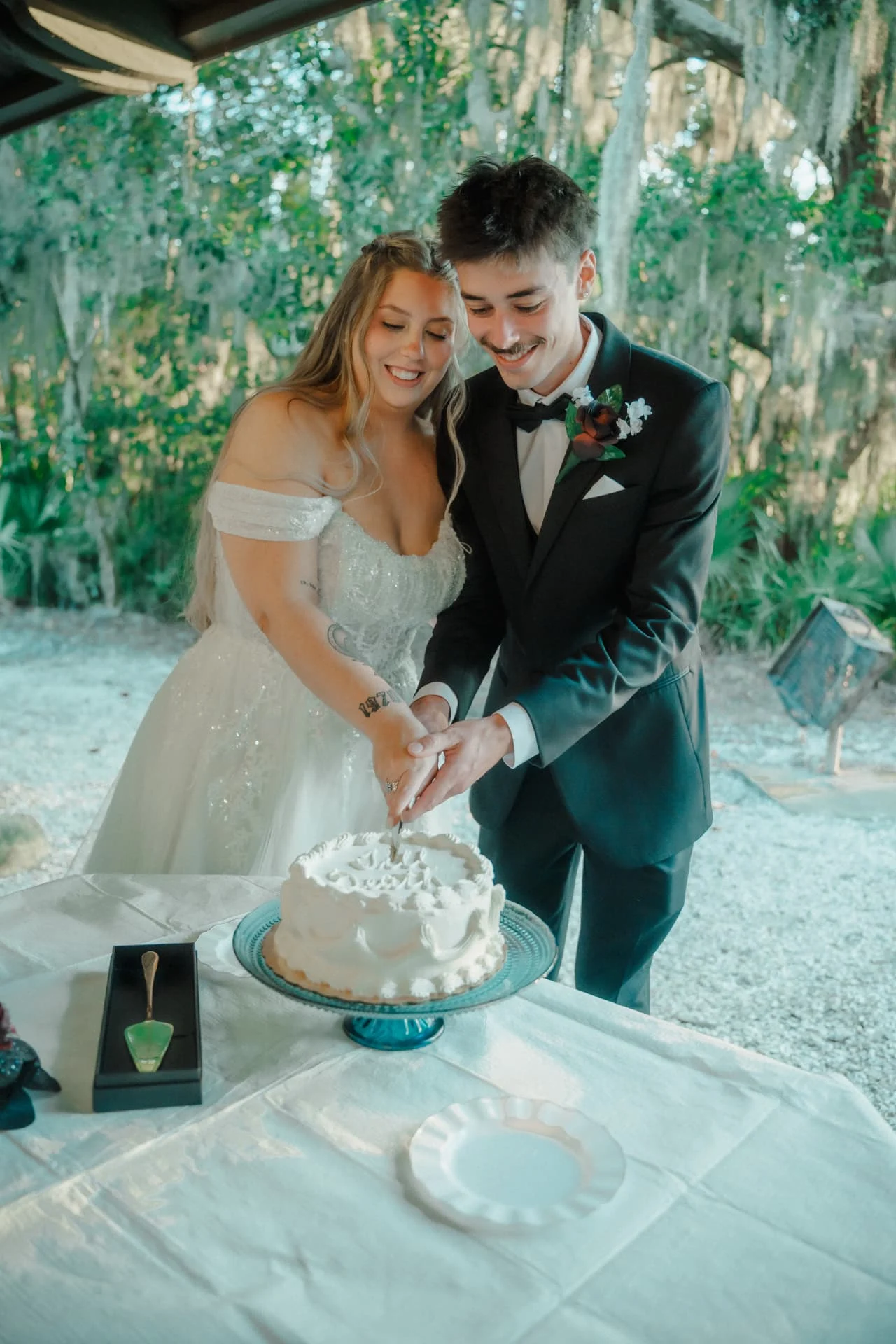 Newlyweds cutting their wedding cake beneath the pavilion