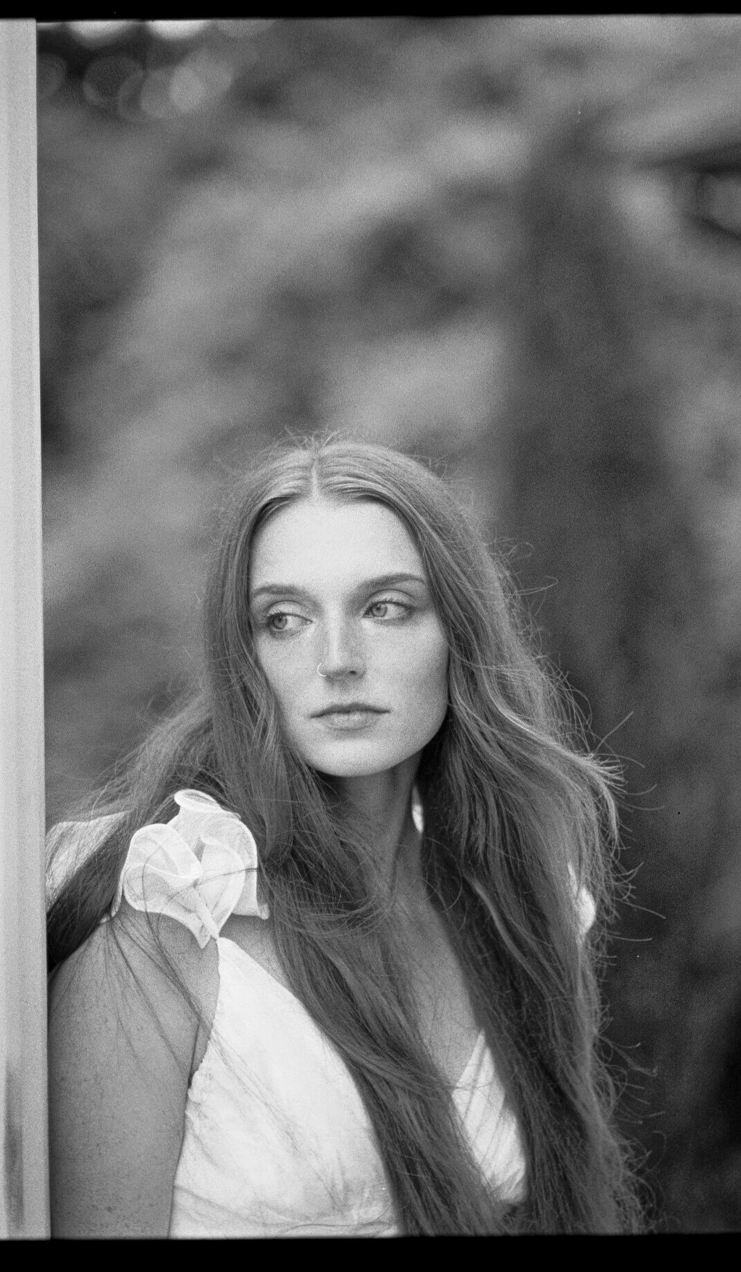 Bride standing in a doorway with a bouquet during a film wedding portrait