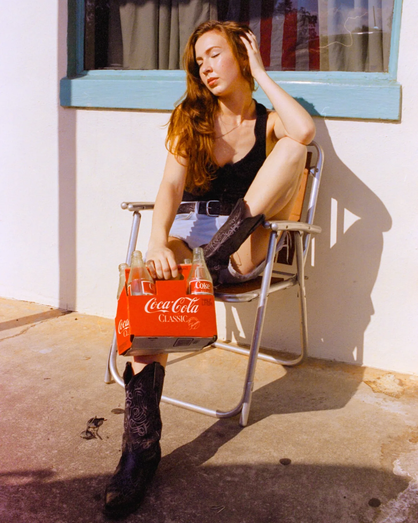 Editorial portrait seated with a Cherry Coke and nostalgic film styling