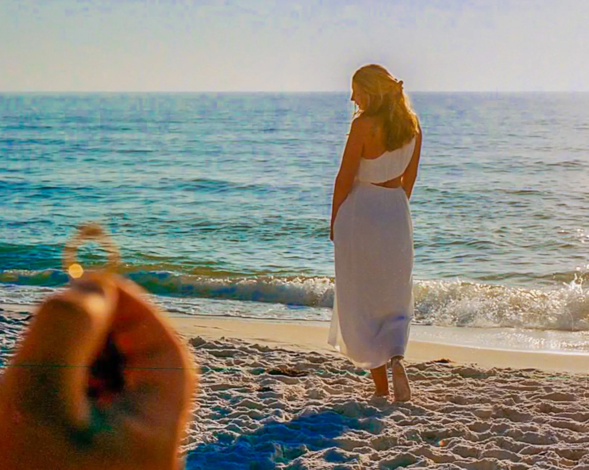Couple embracing on the beach at golden hour, relaxed engagement session portrait