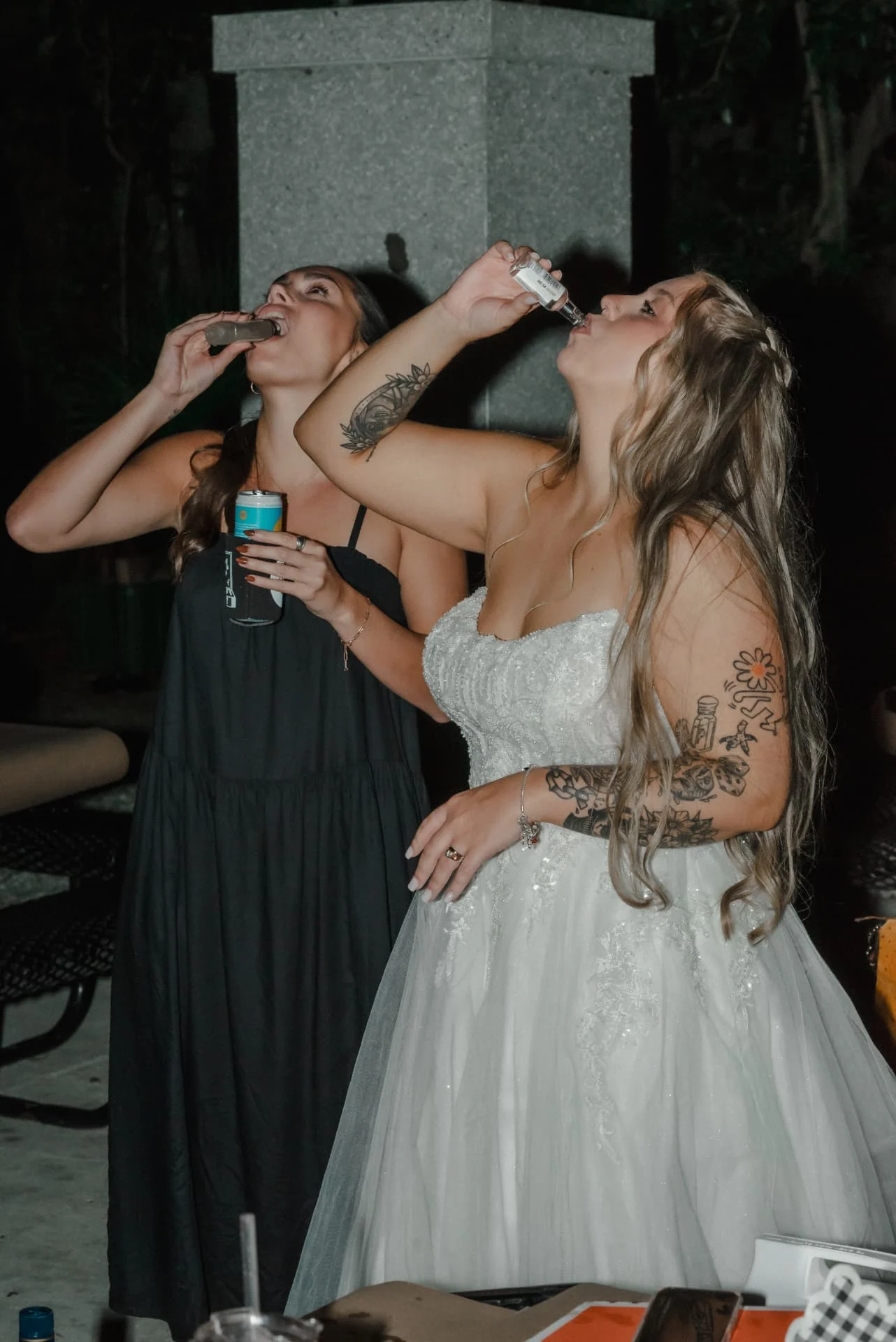 Bride and a friend celebrating with drinks at the wedding reception
